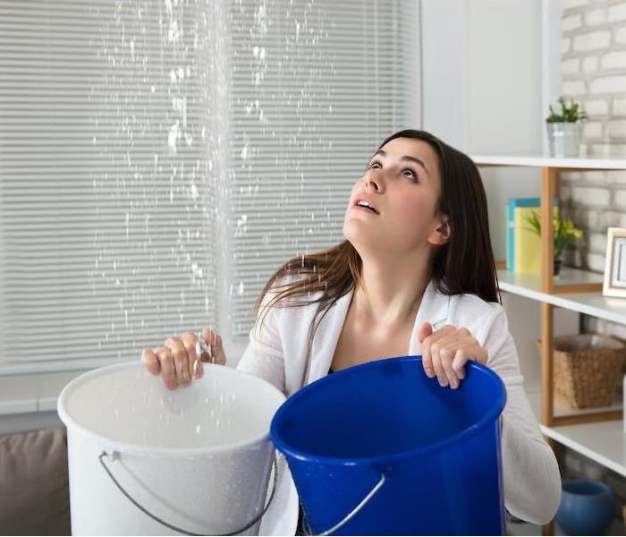 Woman holding buckets for leak